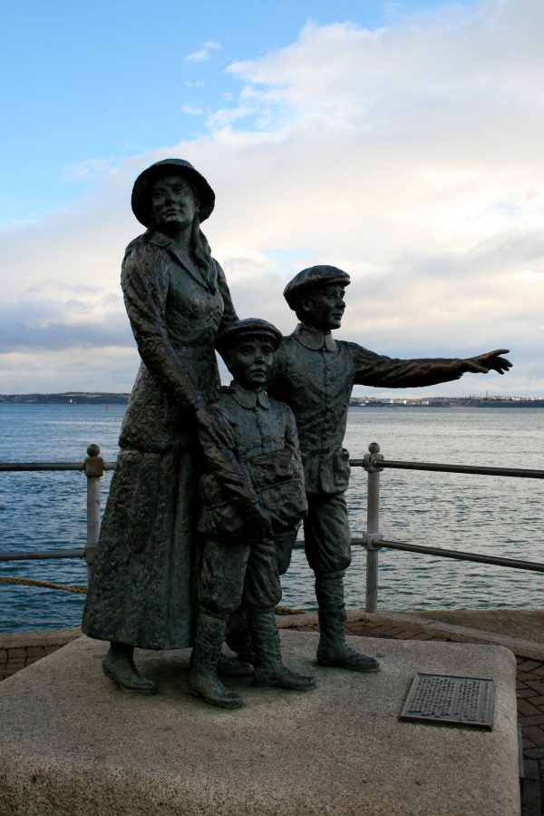 Three statue figures of a family migrating to the US.