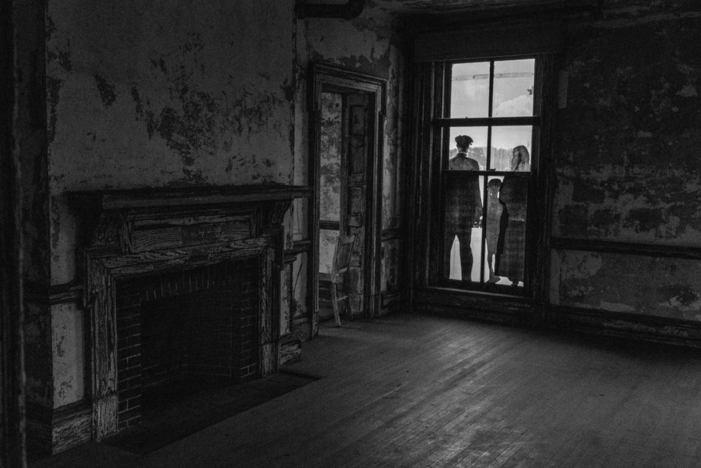 A family standing outside a window in silhouette. 