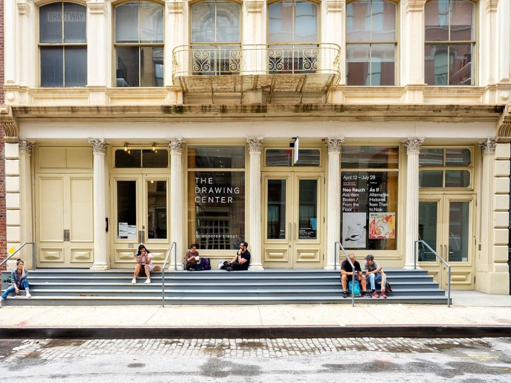 People sitting on the steps of The Drawing Center in SoHo New York City.