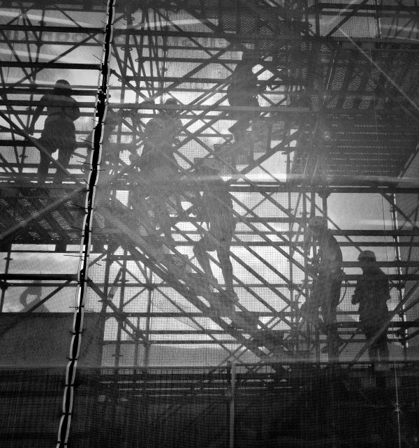 gray scale image of construction workers walking upstairs