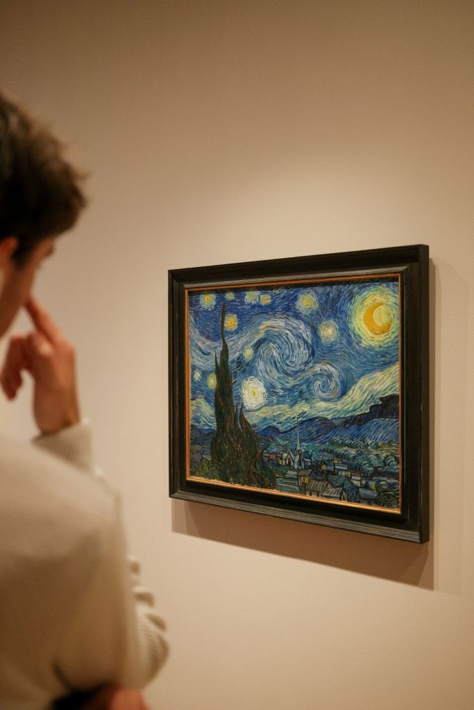 A man looking at The Starry Night, at the MoMA in NYC. 