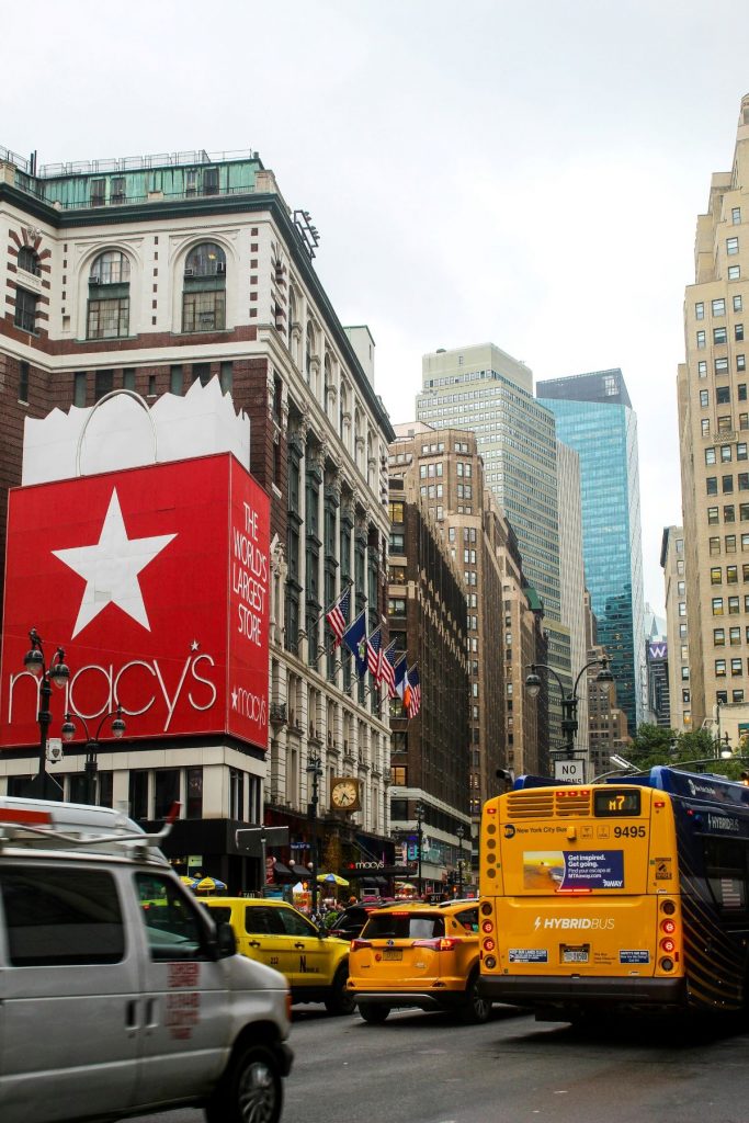 A bustling street with traffic in front of Macy's in New York City.
