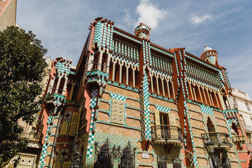 Casa Vicens, a building by Antoni Gaudí, displaying its beautiful exterior consisting of various elements including stone, tilework, wood and wrought iron.