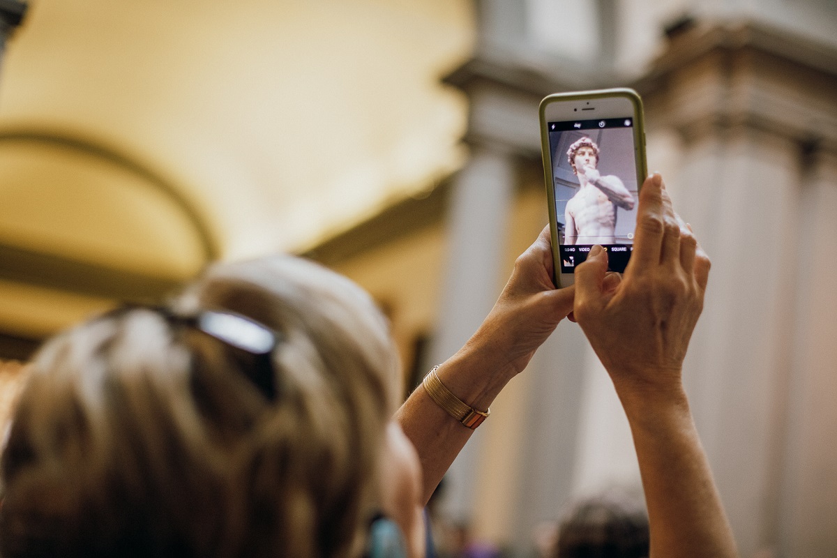 A woman holds up her cell phone to take