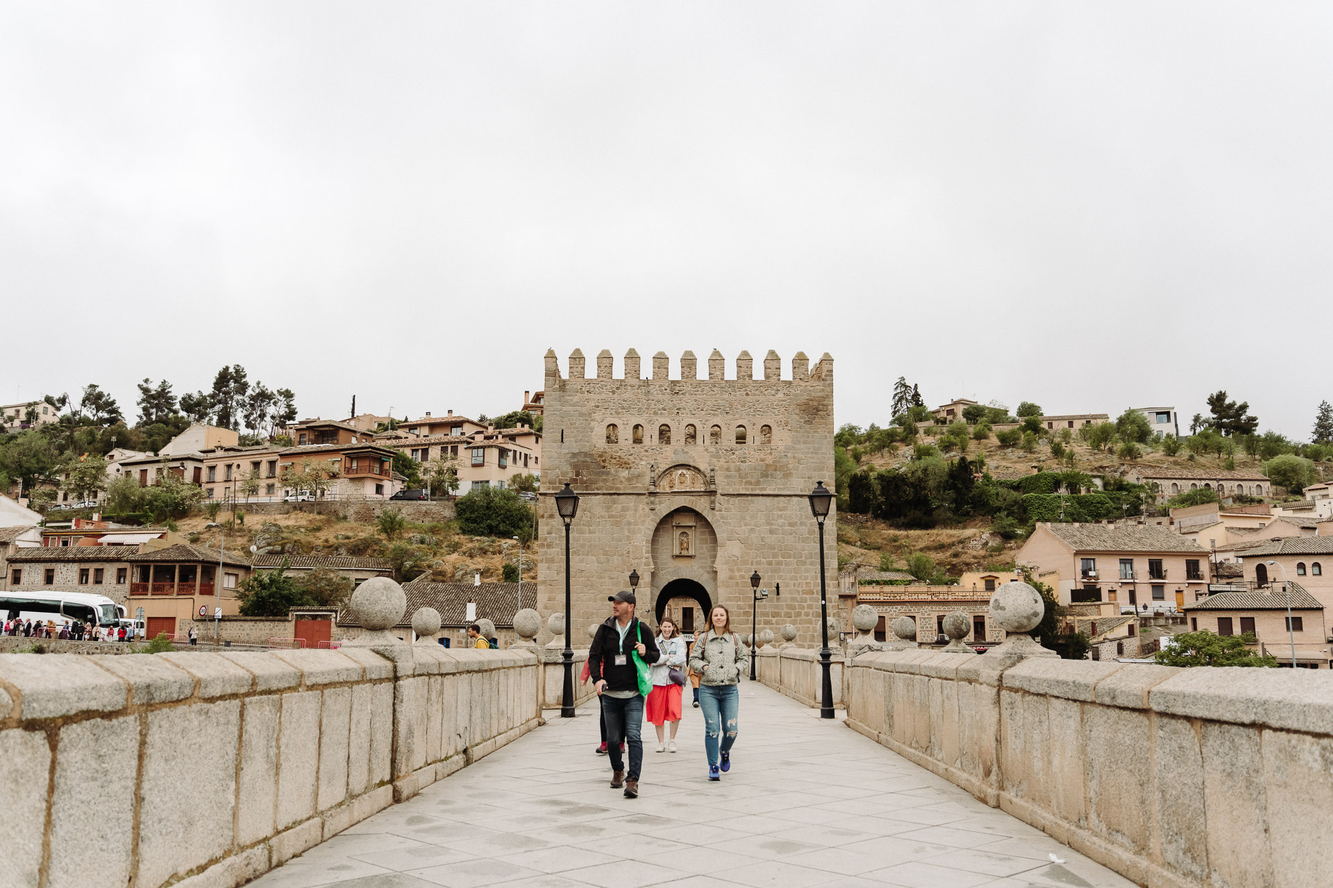 Tour guide leads guests over a bridge in Toledo, Spain