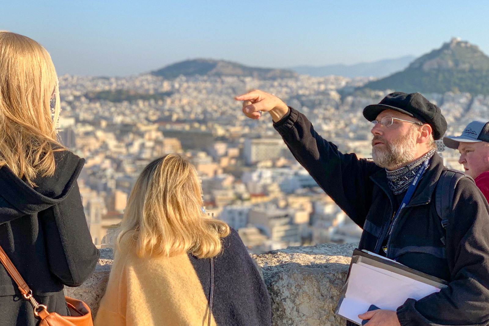 Tour guide in Athens, Greece, points out local landmarks from the top of a hill