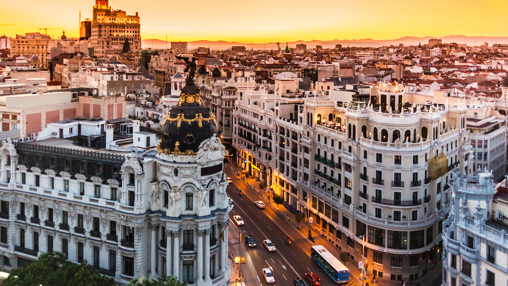 aerial view of Gran Via with the Metropolis Building in the foreground and buses and cars on the street