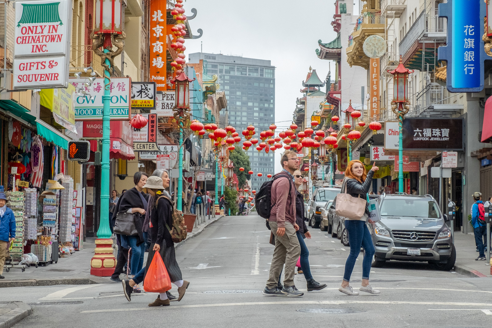 San Francisco chinatown guide crosses street while explaining to tour guests what they are seeing