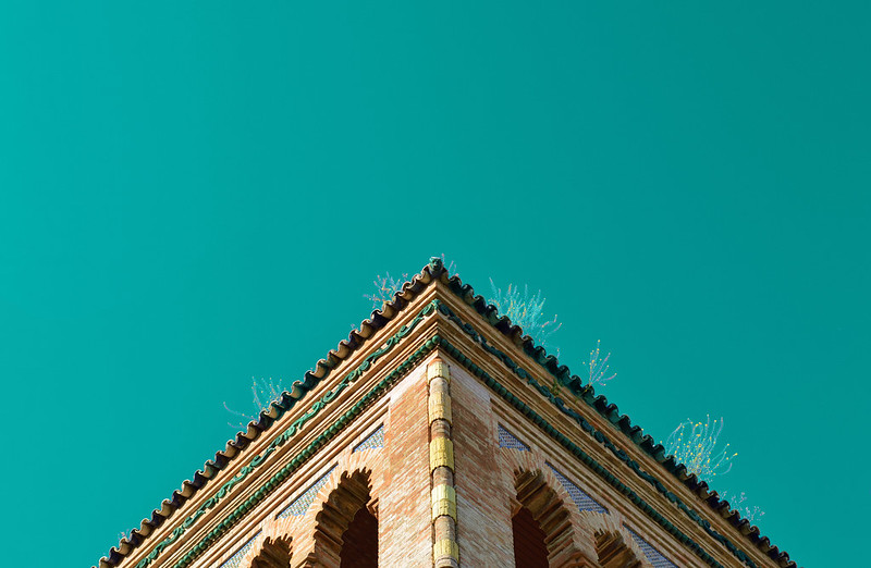 A view of the corner of the Museo de Artes y Costumbres Populares building with a clear blue sky in the background.