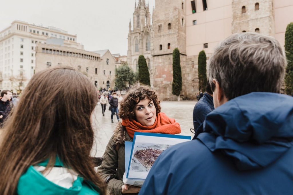 A tour guide engages a group of people in central Barcelona, near the cathedral