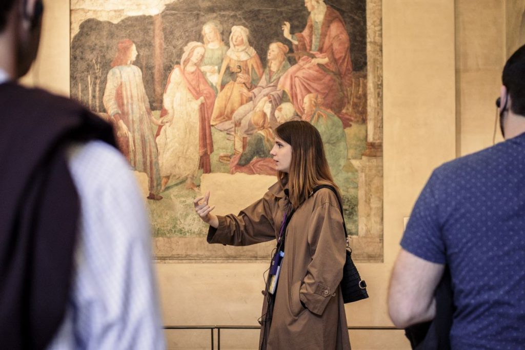 A guide explaining a painting inside a museum