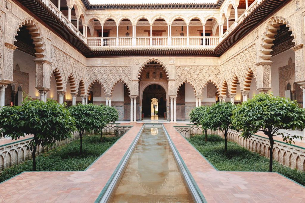 A view inside Seville's Alcazar displaying a fountain and the building's stunning facade