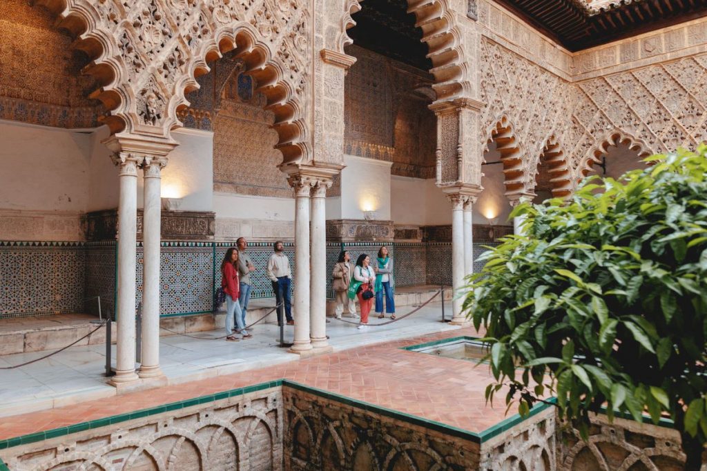 A group stands in the center of Seville's Alcazar, admiring its beauty