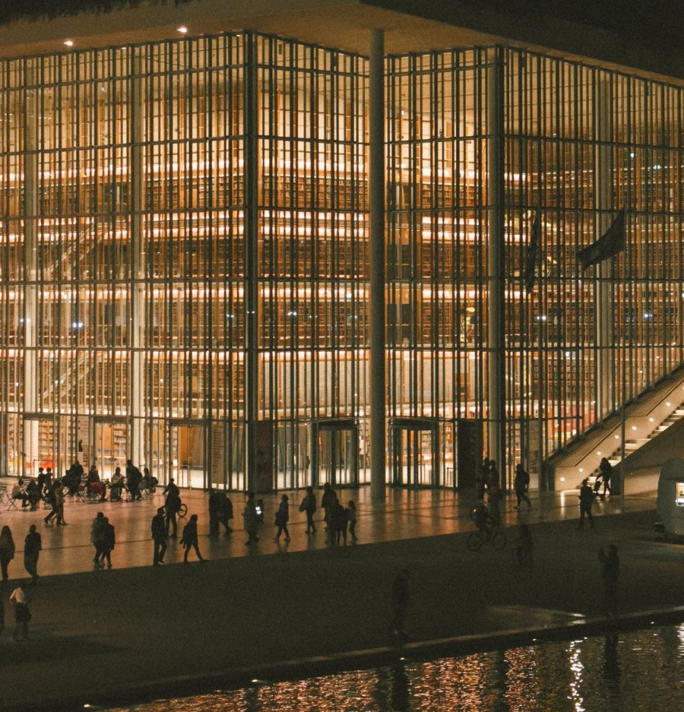 A nighttime view of the Stavros Niarchos Foundation Cultural Center in Athens, Greece, iluminated at night.