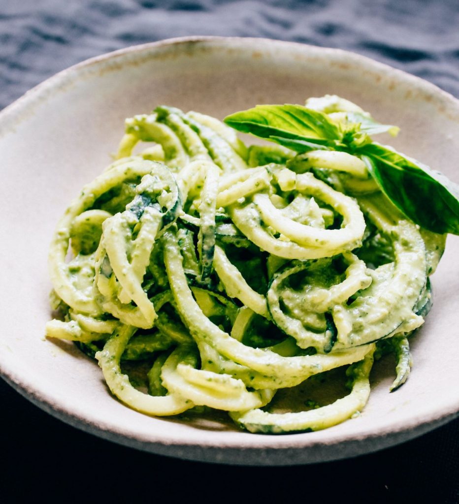 A bowl of pasta with a creamy pesto sauce.