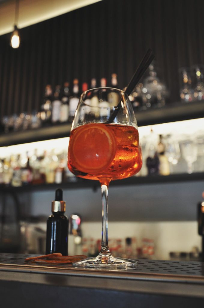 An Aperol Spritz sat on a bar.