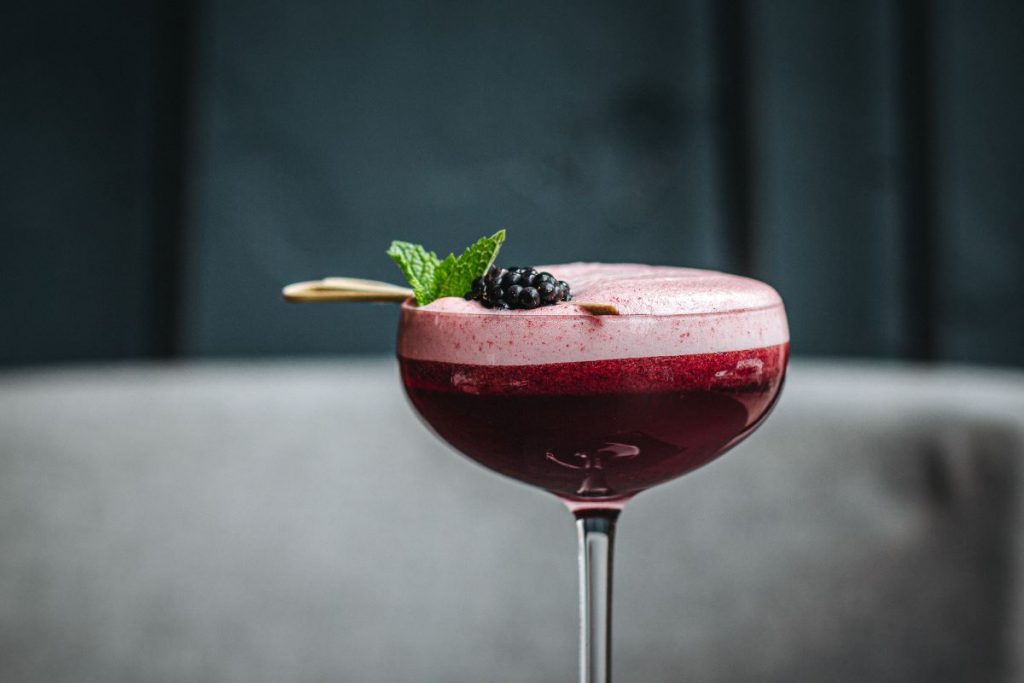 A cocktail with blackberry and mint