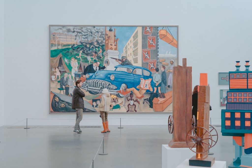 A man and woman stand in front of a painting at the Tate Modern