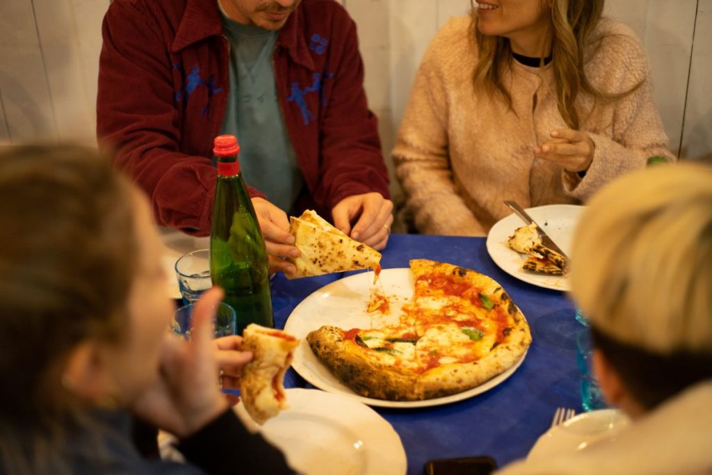 people eating pizza at a restaurant
