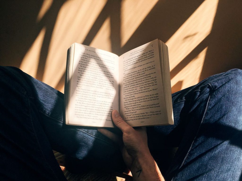 someone sitting on the floor reading a book