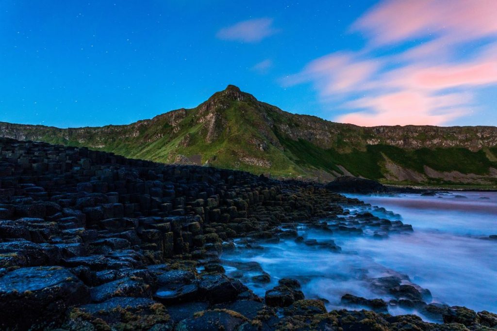 rocks along the water with a beautiful sunset in the background