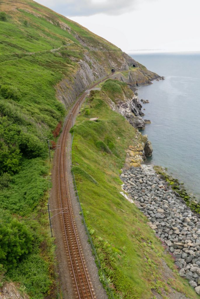 train tracks on a hill overlooking water