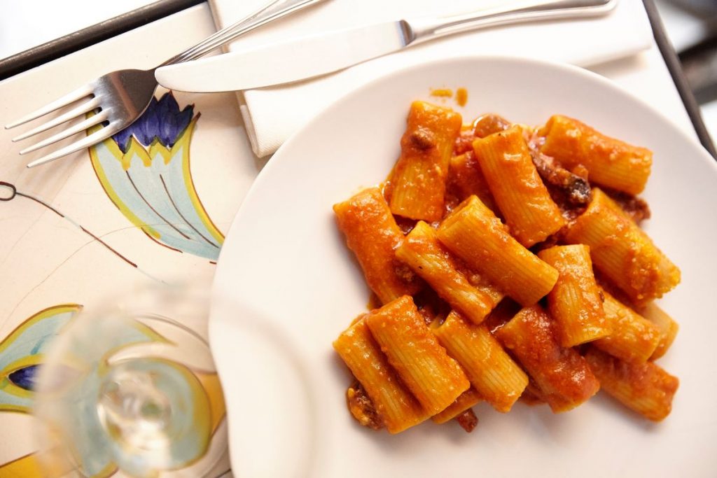 A plate of pasta with red sauce and meat