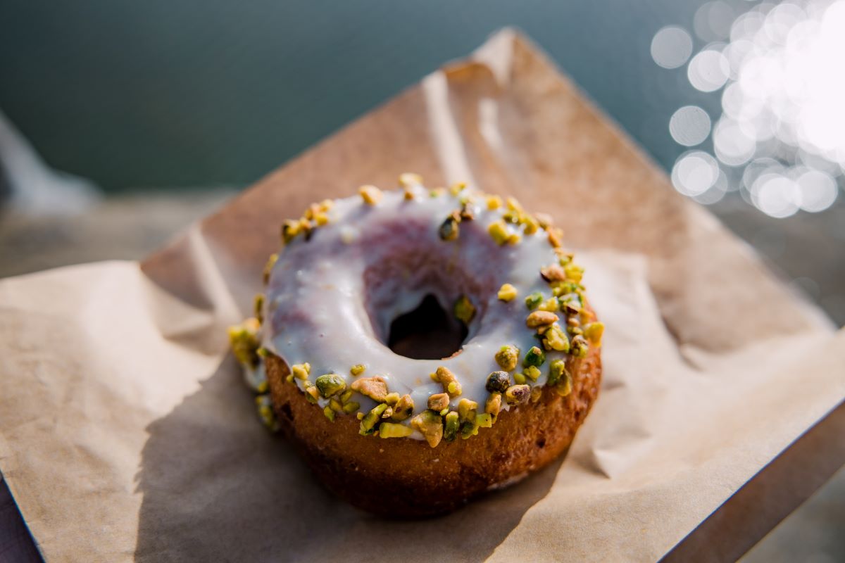 Closeup of a glazed doughnut with pistachio.