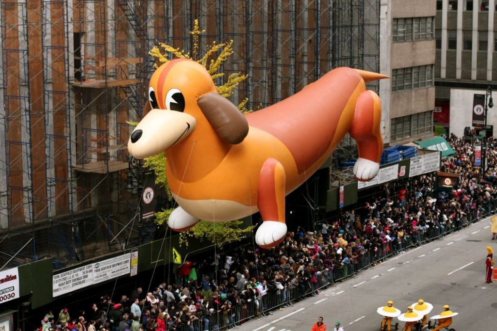 giant balloon in parade with people on the street