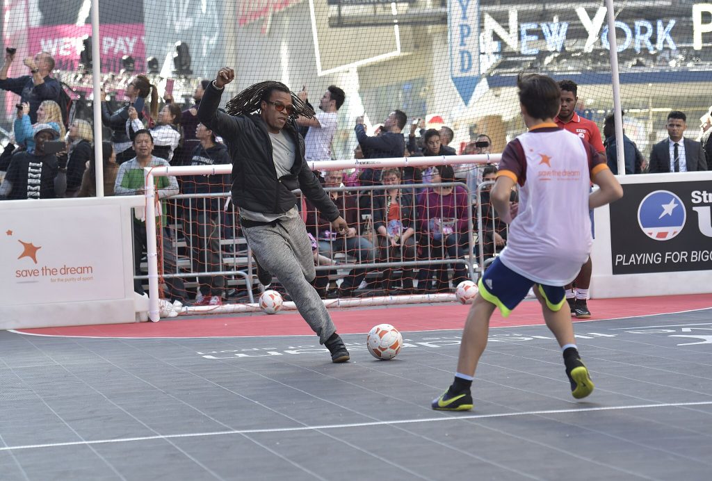 person kicking a ball at an event in Times Square