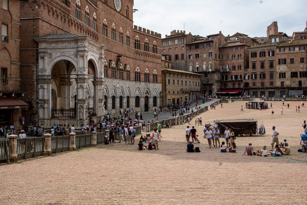 People relaxing in the Piazza del Campo in Siena, a day trip from Florence