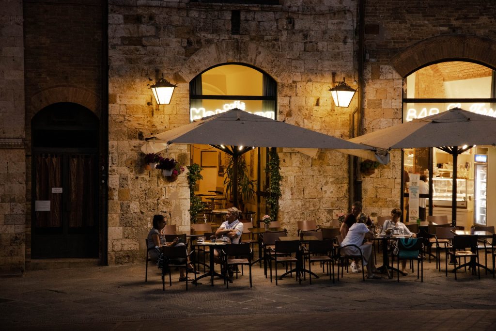 Tuscan terrace with dim light and people sitting outside summer