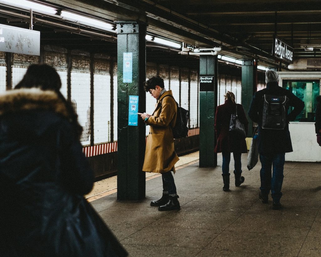 man looking at his phone in a subway station