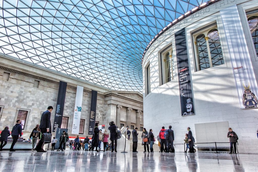 People walking inside The British Museum with architecture and blue sky