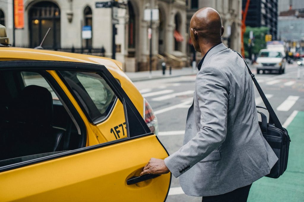 Person hailing a NYC taxi sunny day