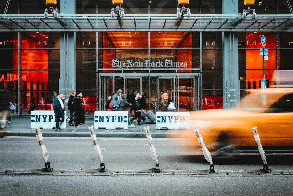 A taxi going by in front of the New York Times Building