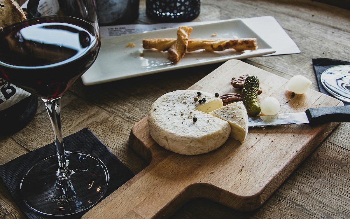 Table of cheese snacks and glass of wine