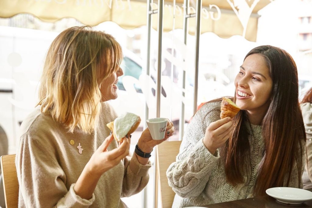 friends enjoying coffee and pastries together in a bar