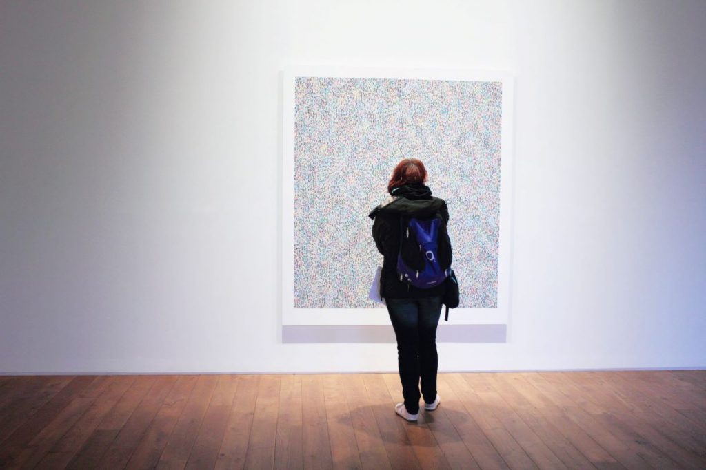 girl looking at painting inside a museum