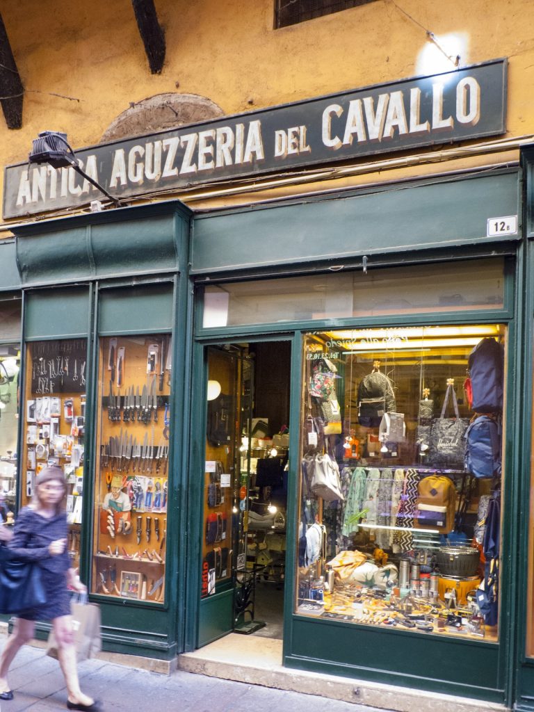 woman walking in front of Antica Aguzzeria del Cavallo