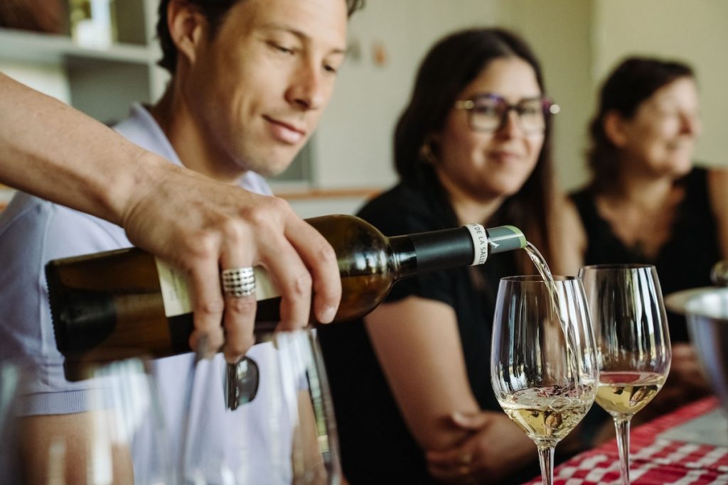 white wine being poured into two glasses