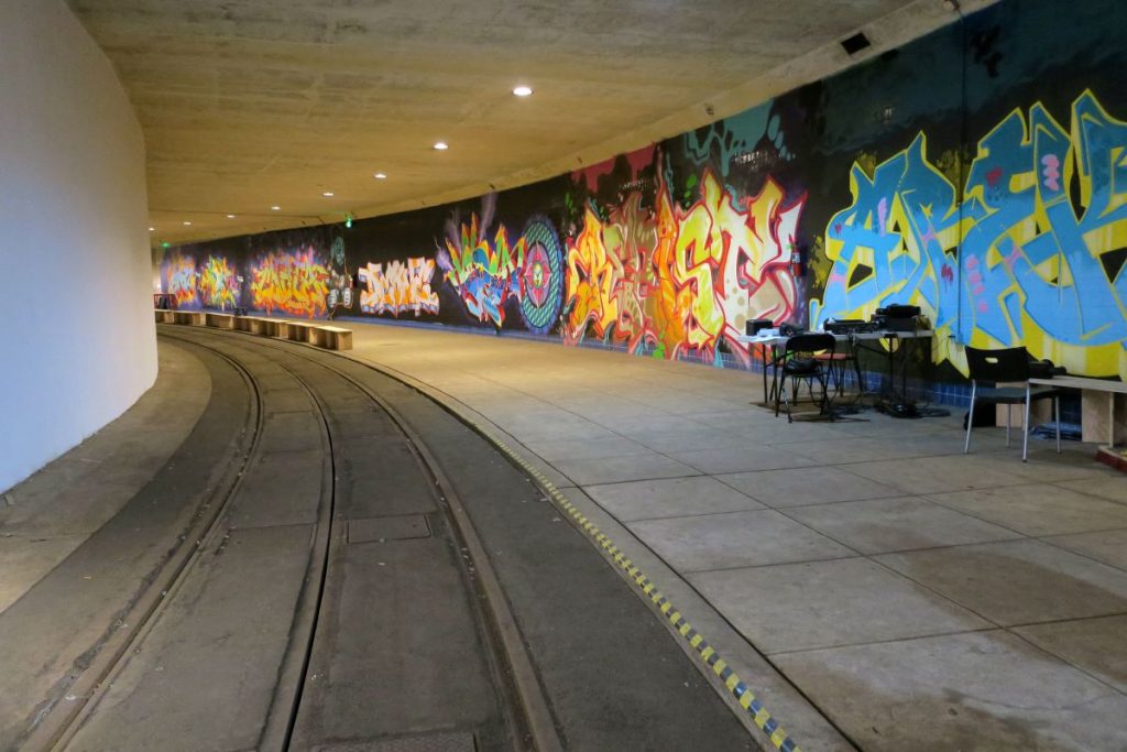 underground tunnel with a wall full of graffiti