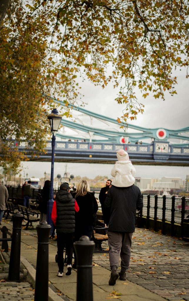 family walking near Tower Bridge in London exploring the city together. 