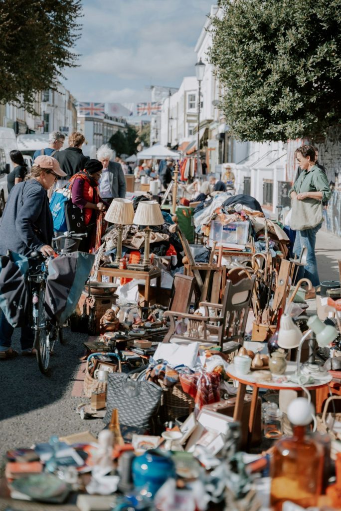 People walking around searching the antiques markets in London on a sunny day. 