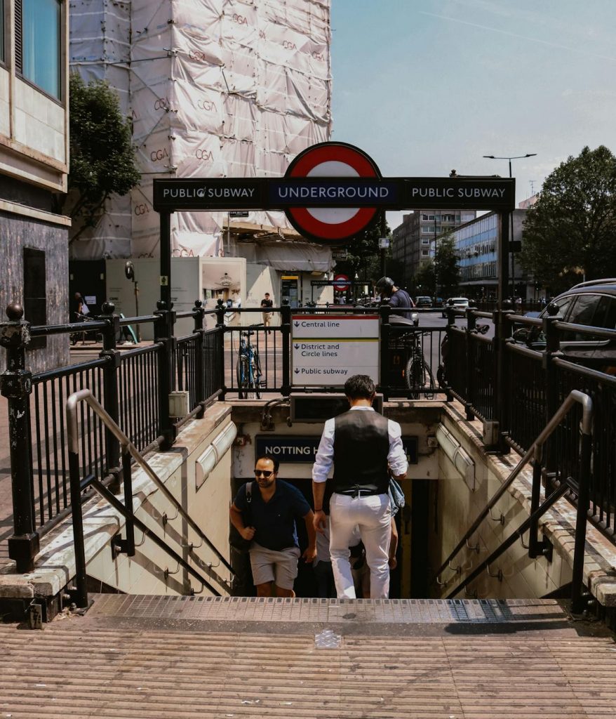 A man walking down stairs to get to the London Underground.