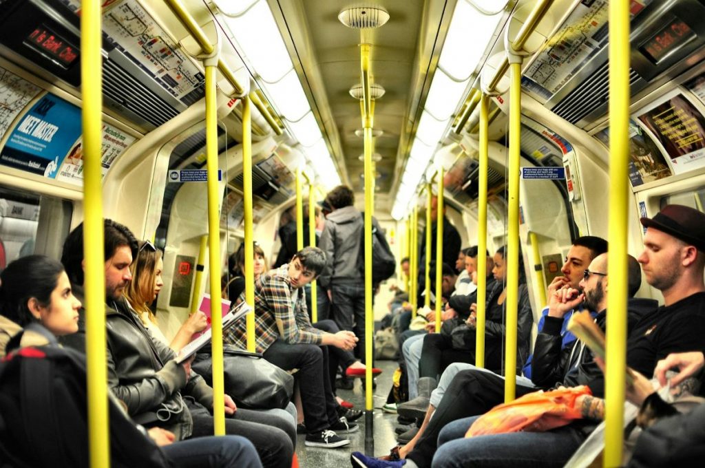 People using the Tube on a crowded train car.