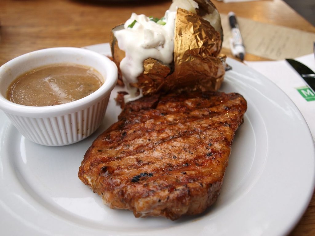 Grilled steak with baked potato and gravy
