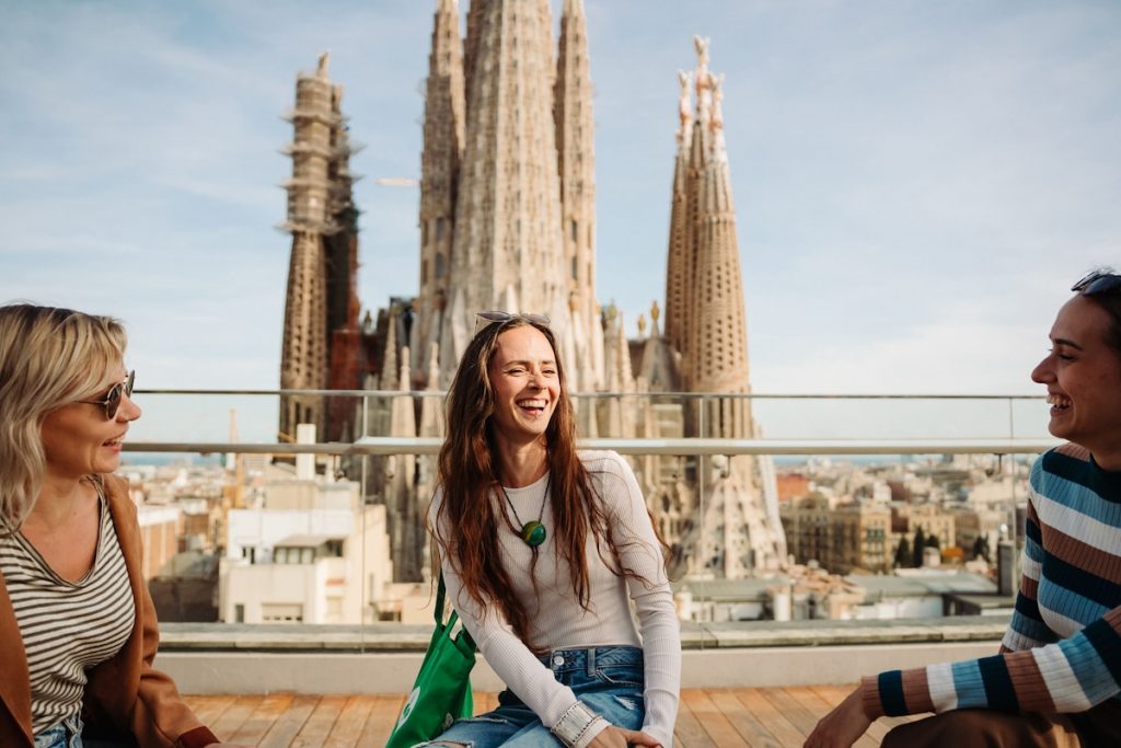 girls sitting with views of sagrada familia in the background