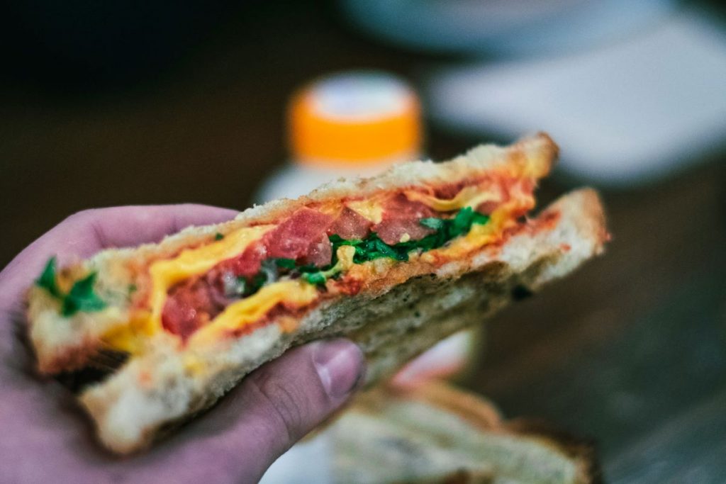 person holding a sandwich at Chelsea Market in New York City. 