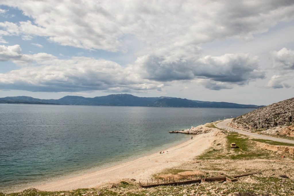 coast line of sandy beach with low mountains in the background